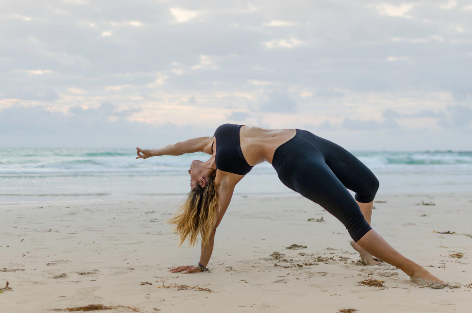 Woman does yoga on the beach