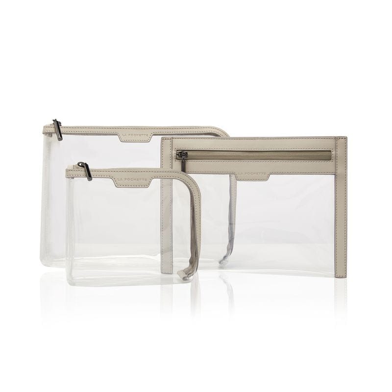 A collection of 3 cabin approved La Pochette clear travel pouches with beige trims and taupe zips. Include a small and large pouch and a wallet.