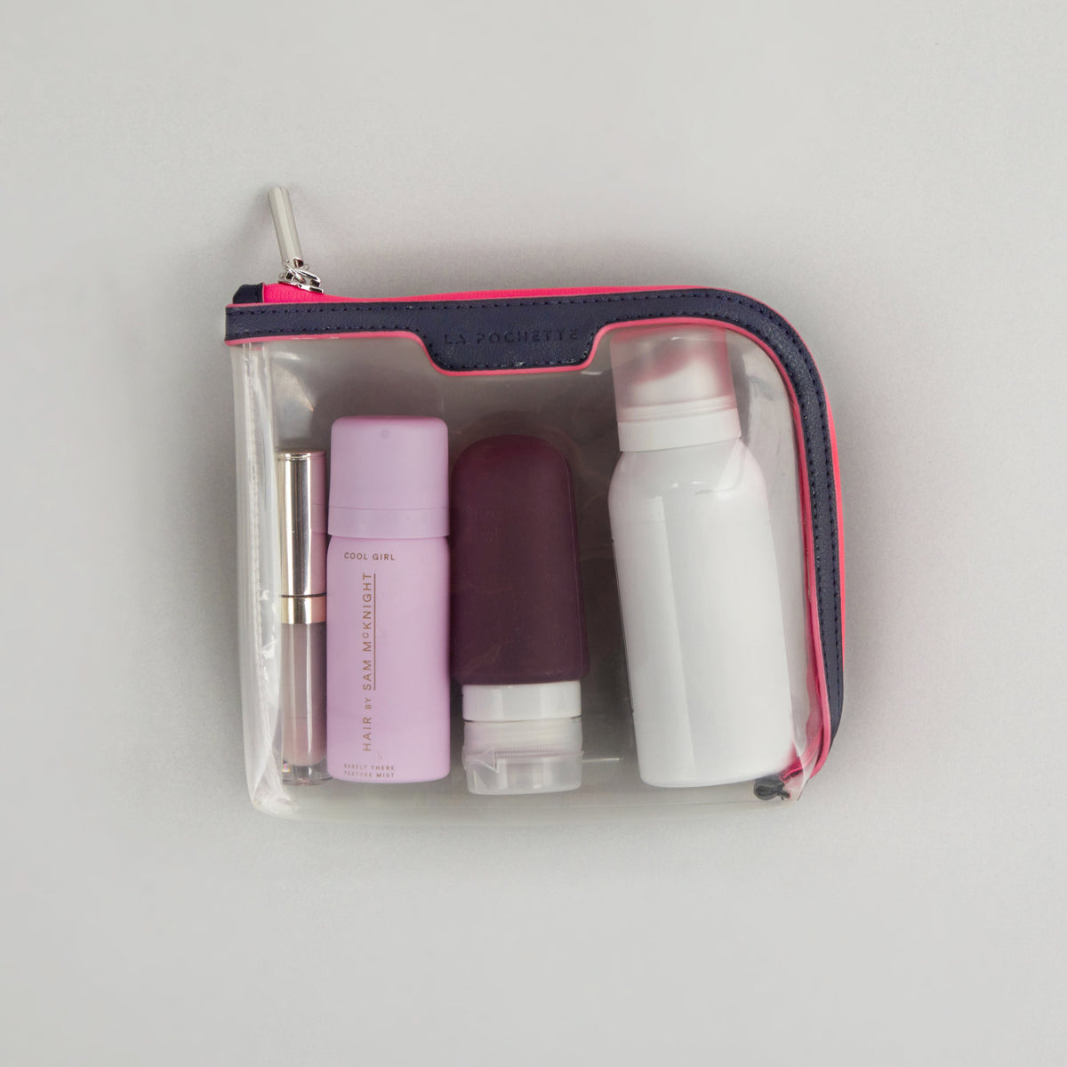 Small Anywhere Everywhere Pouch in Midnight Neon Pink colourway containing beauty accessories 