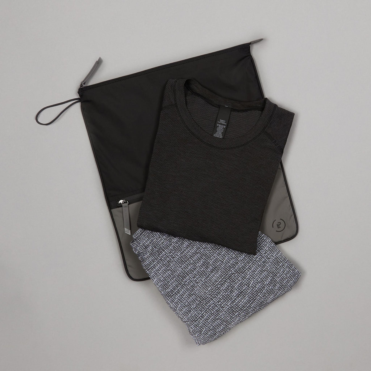 Ink Pewter Sweat Bag shown flat, with folded gym clothes