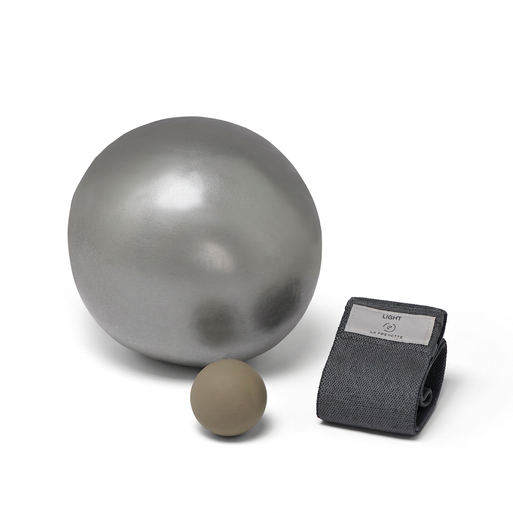 A metallic grey Inflatable Pilates ball, a small beige recovery ball and a dark Grey resistance band with a LA POCHETTE logo woven label photographed on a clean white background.