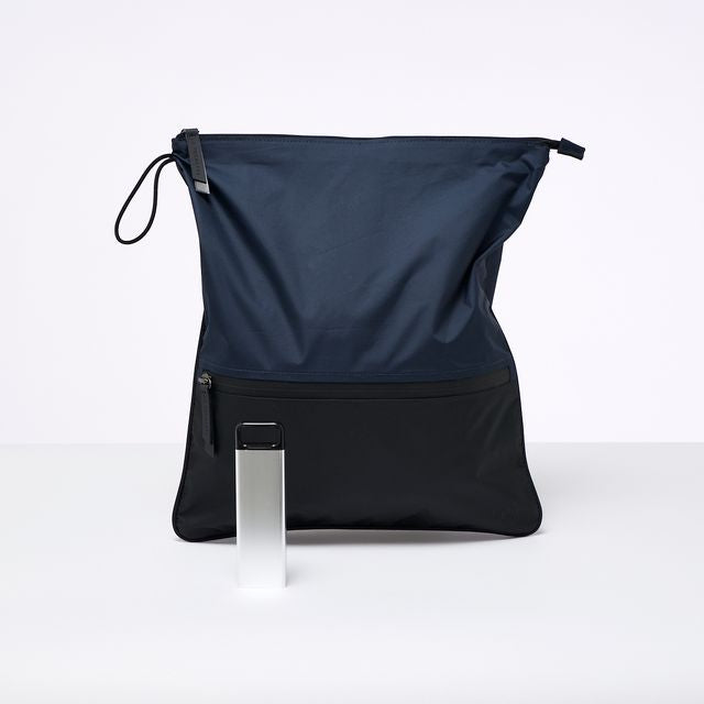 A Black and navy La Pochette antimicrobial sweat bag ,shown with a 3 day stainless steel supplement box. On a white background