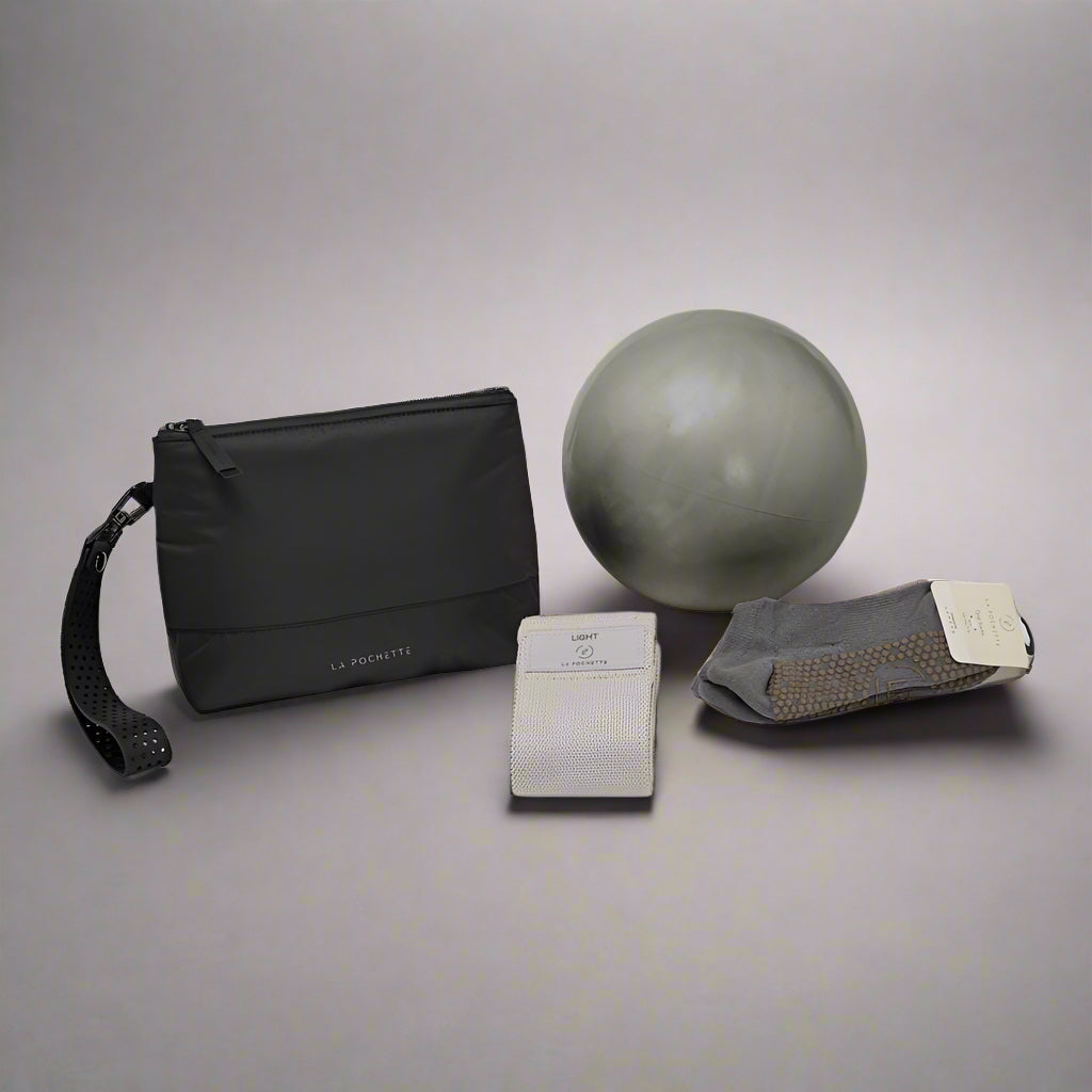 Black pouch, grey exercise ball, grey resistance band, and grey grip socks on a white background