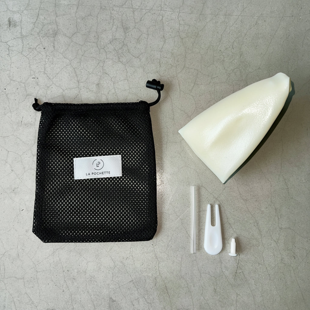 A black La Pochette mesh bag with deflated ivory inflatable Pilates ball, together with straw stopper and stopper removal 
