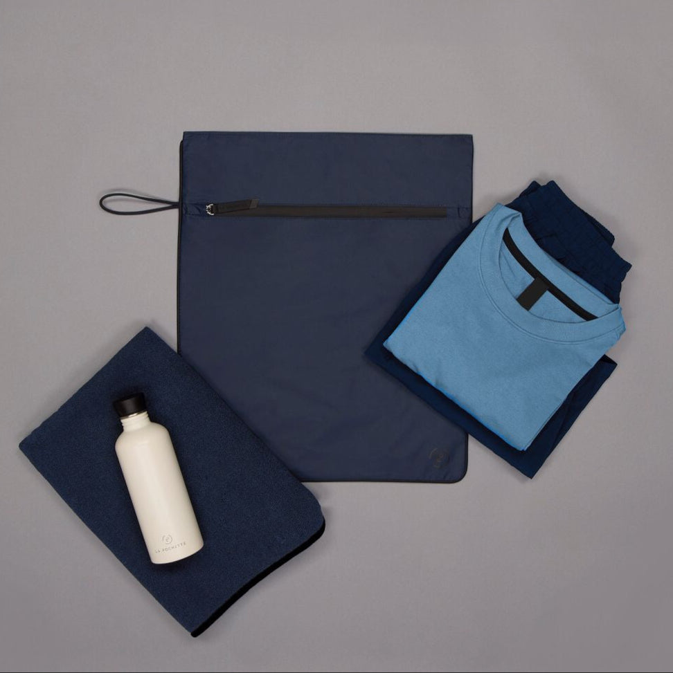 Navy Kit Bag with black trims styled with folded men's workout clothes, navy towel and water bottle