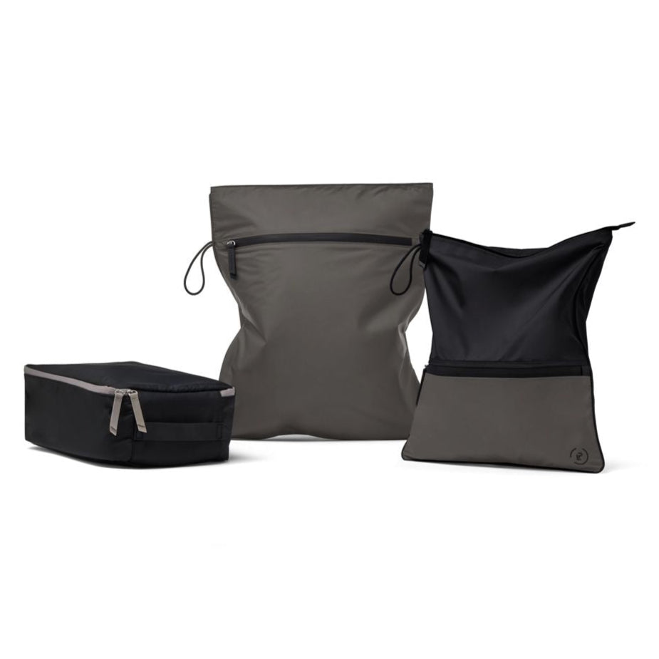 Three-piece workout bag bundle, including a structured black shoe bag, a larger grey waterproof kit bag, and a two-tone black and grey sweat bag, designed for organised gym and travel storage.