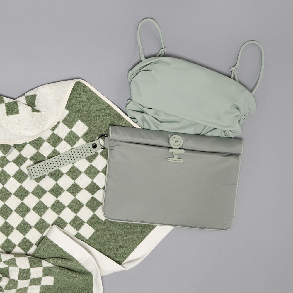 Green swimsuit under a large La Pochette GreenWet Bag  with a green checked towel