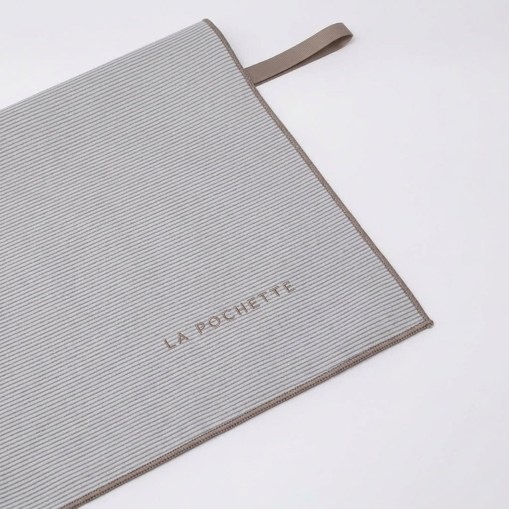 A grey highly absorbent microfiber towel with a dark navy trim, and a matching navy loop handle. The brand name 'LA POCHETTE' is printed in navy on the front, set against a clean white background.