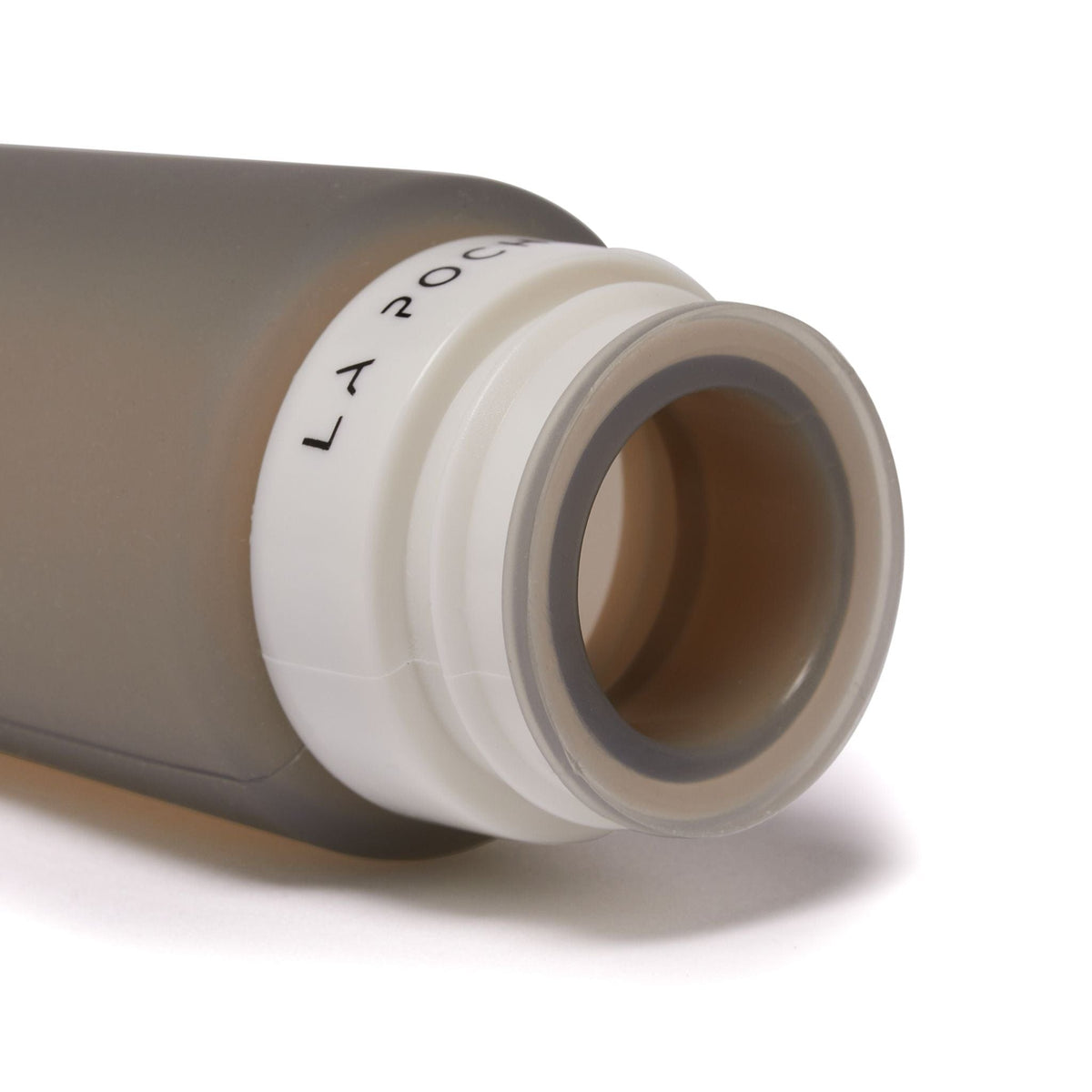 Close-up of silicone travel bottle with lid removed, showing wide opening for easy filling and cleaning