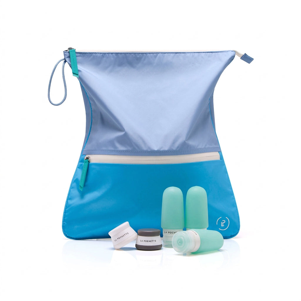 Vivid blue and turquoise sweat bag styled with the three turquoise La Pochette silicone travel bottles in turquoise and the La Pochette travel pots in grey and white.  On a white background.