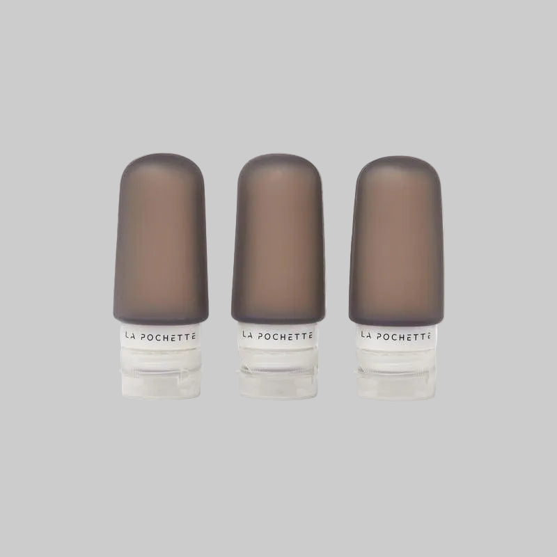 La Pochette leakproof Travel Bottle Trio in dark taupe showing logo on the neck.