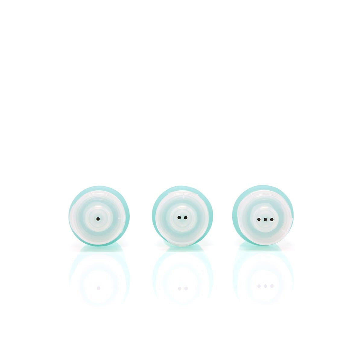 Close-up of travel bottle lids showing the dot indicators — one, two and three dots — to help identify contents