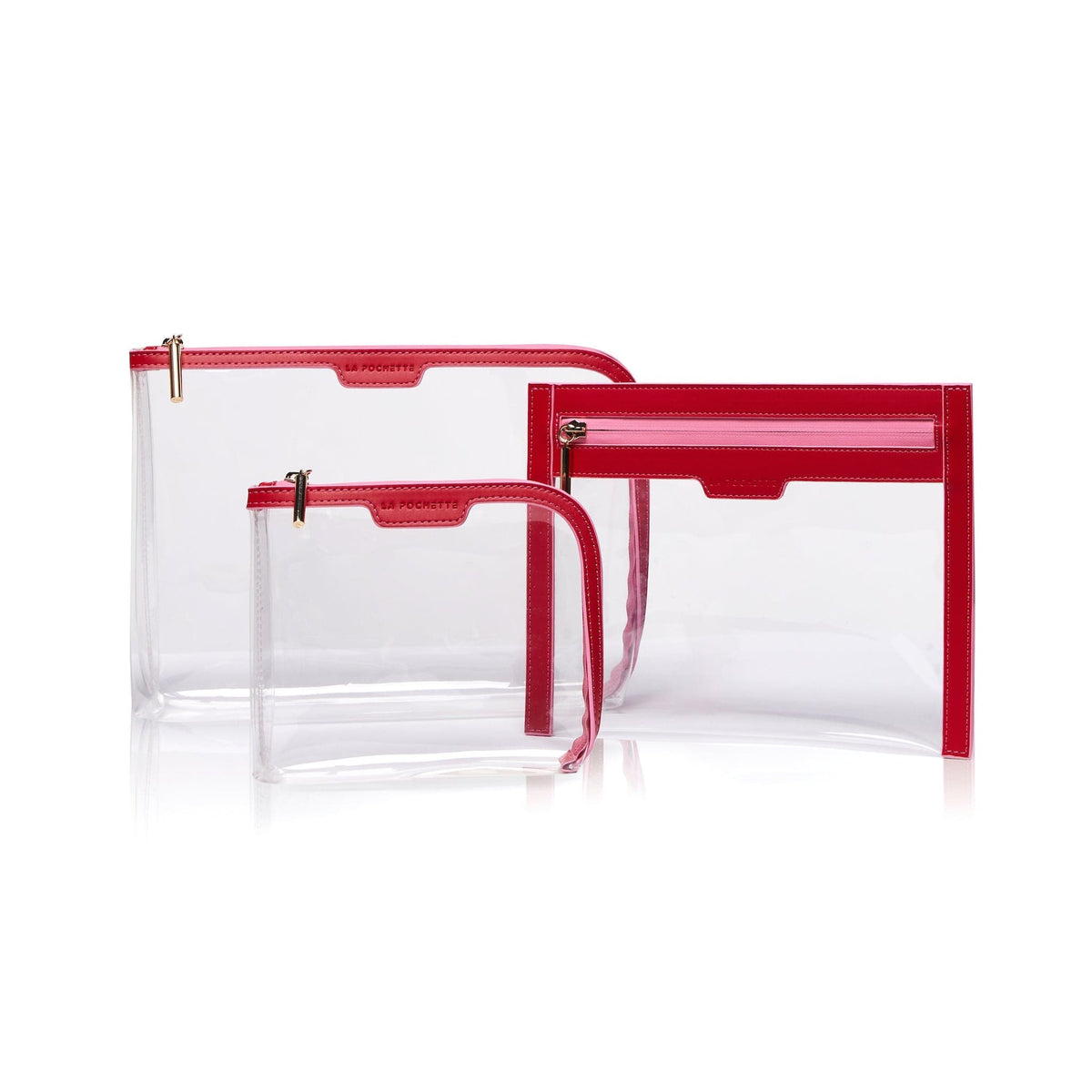 A collection of 3 cabin approved La Pochette clear travel pouches with red trims and pink zips. Include s a small pouch, large pouch and wallet.