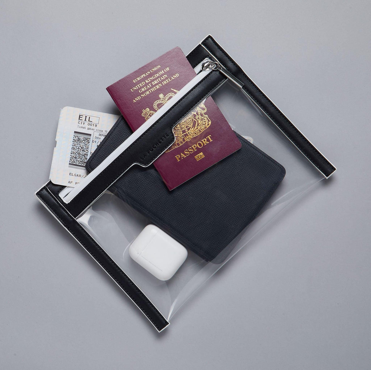 La Pochette Clear Wallet with black and white trims. Passport, ticket, AirPods and kindle inside wallet. 
