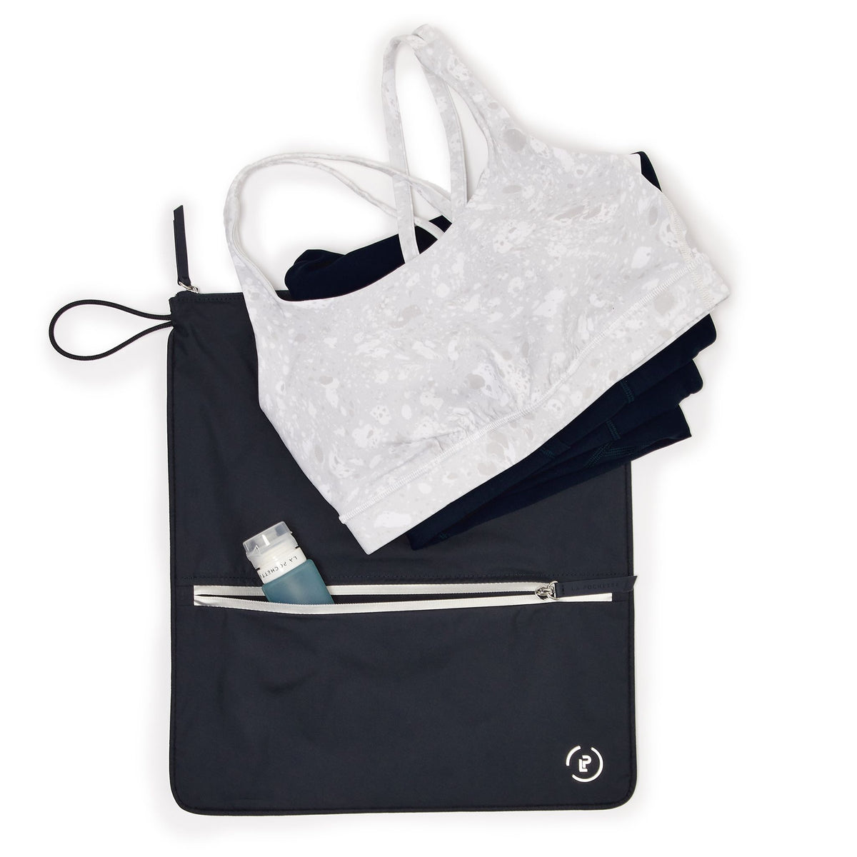 Midnight Silver Sweat bag laying flat, with front pocket open with a travel bottle inside, and workout kit on top of sweat bag.