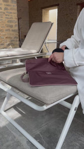 Video of putting swimsuit in the la pochette waterproof wet bag in burgundy and rose pink. 