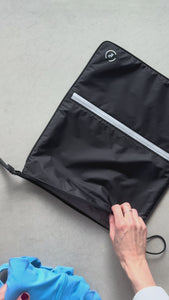demonstration of the sweat bag in black and silver in use, packing gym kit into the bag then into a tote bag with a laptop