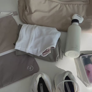 demonstration of using the sweat bag in taupe and beige, packing gym kit into the sweat bag and then putting it into a tote bag with other essentials