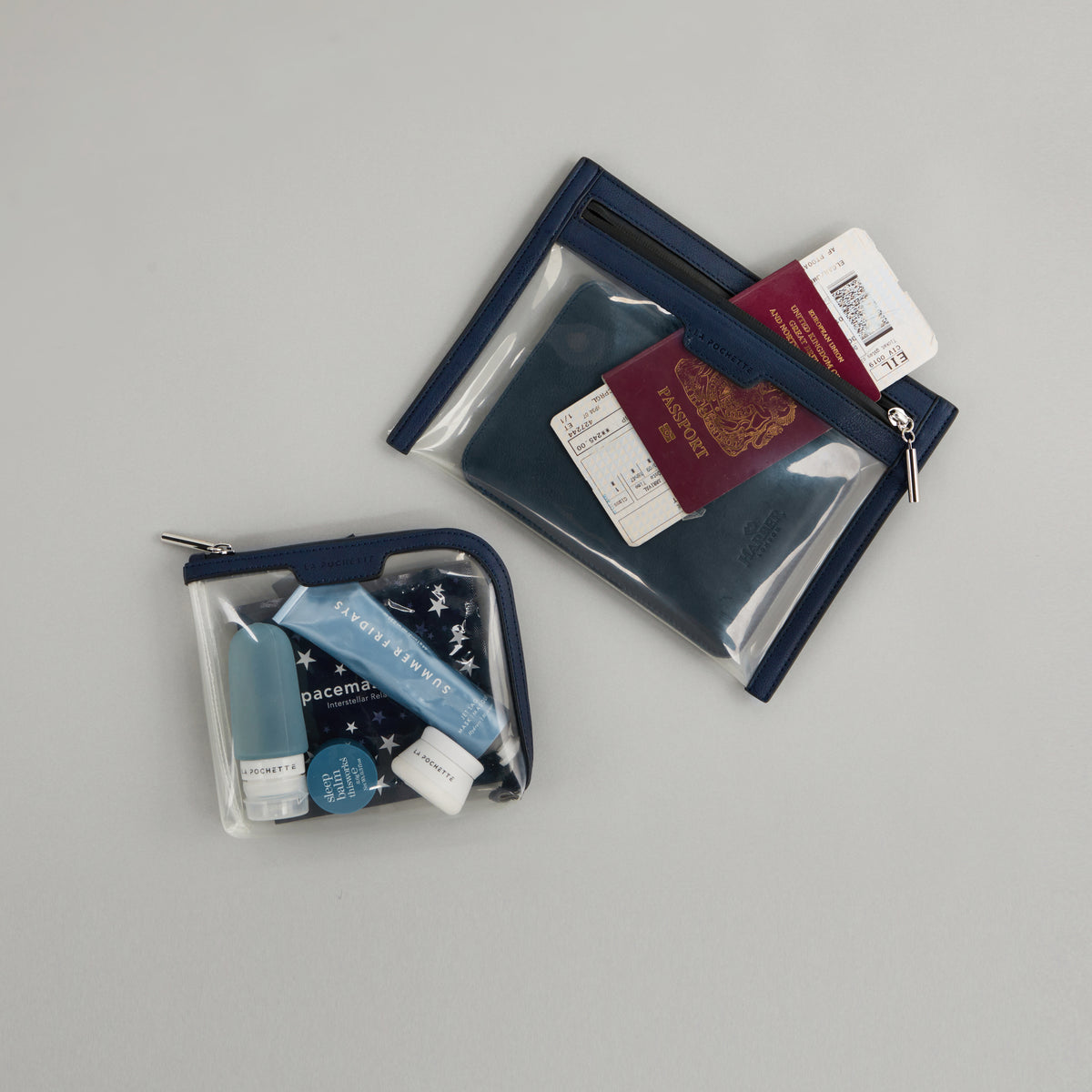 Small Anywhere Everywhere Pouch in Midnight Ink colourway containing beauty acessories, next to Wallet Anywhere Everywhere Pouch in Midnight Ink colourway holding a passport 