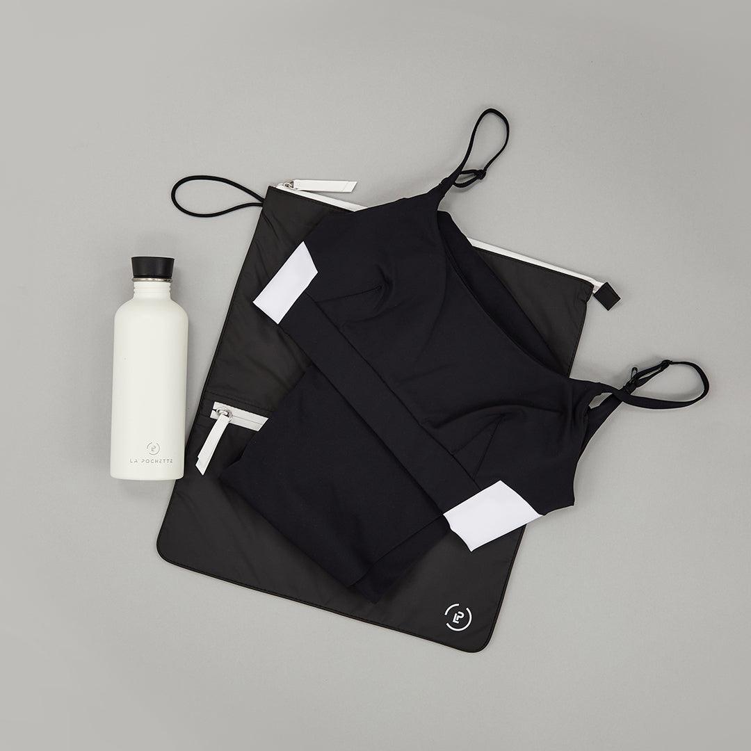 Ink White Sweat Bag shown flat, with folded gym clothes and La Pochette water bottle