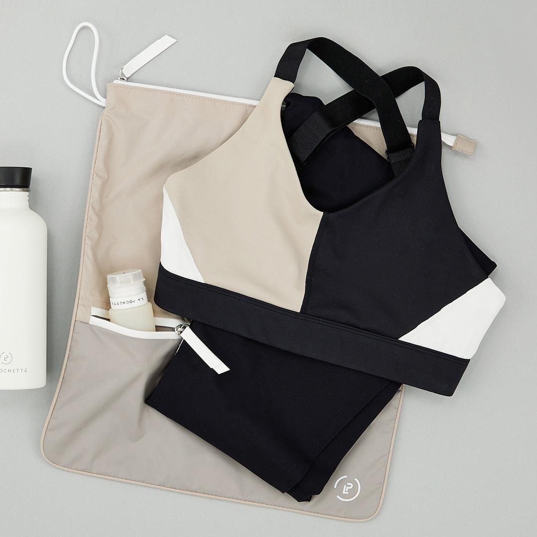 Cashmere Walnut Sweat Bag shown flat, with folded gym clothes and La Pochette silicone travel bottles