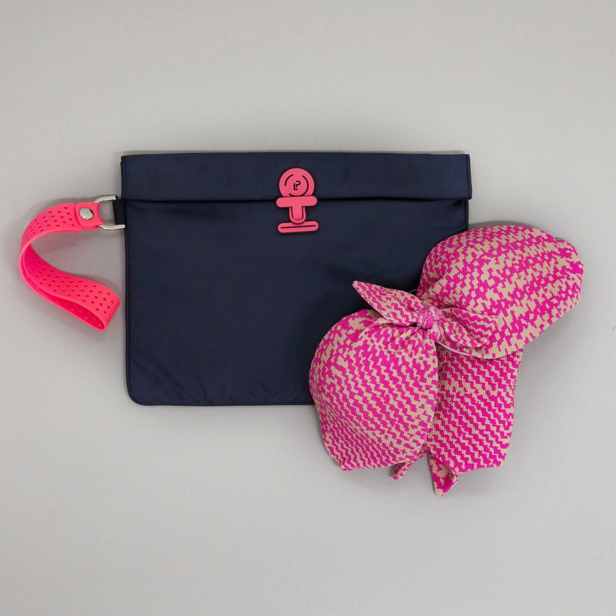 Small Wet Bag in Midnight Neon Pink colourway shown flat with a bikini placed on top