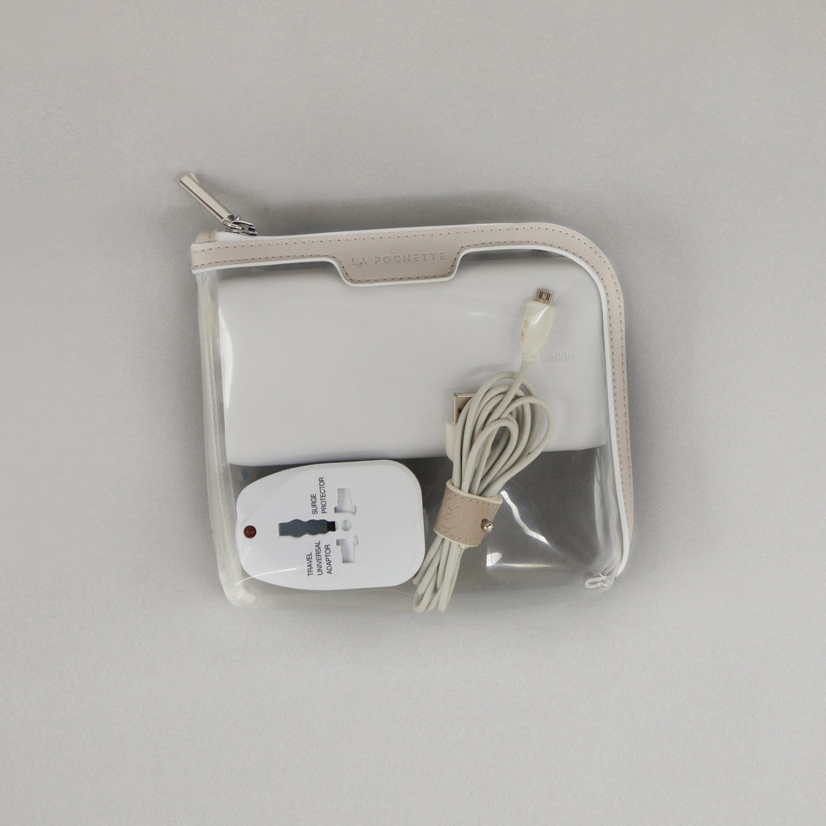 Small Anywhere Everywhere Pouch in Cashmere White colourway containing Cable Tidy in Cashmere White colourway and travel plug adapter