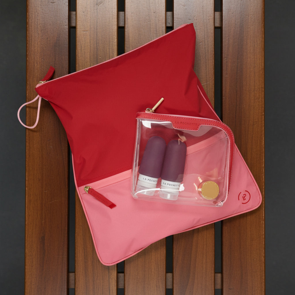 Small Anywhere Everywhere Pouch in Chilli Peony colurway containing La Pochette silicone travel bottles, resting on Sweat Bag in Chilli Peony colour way