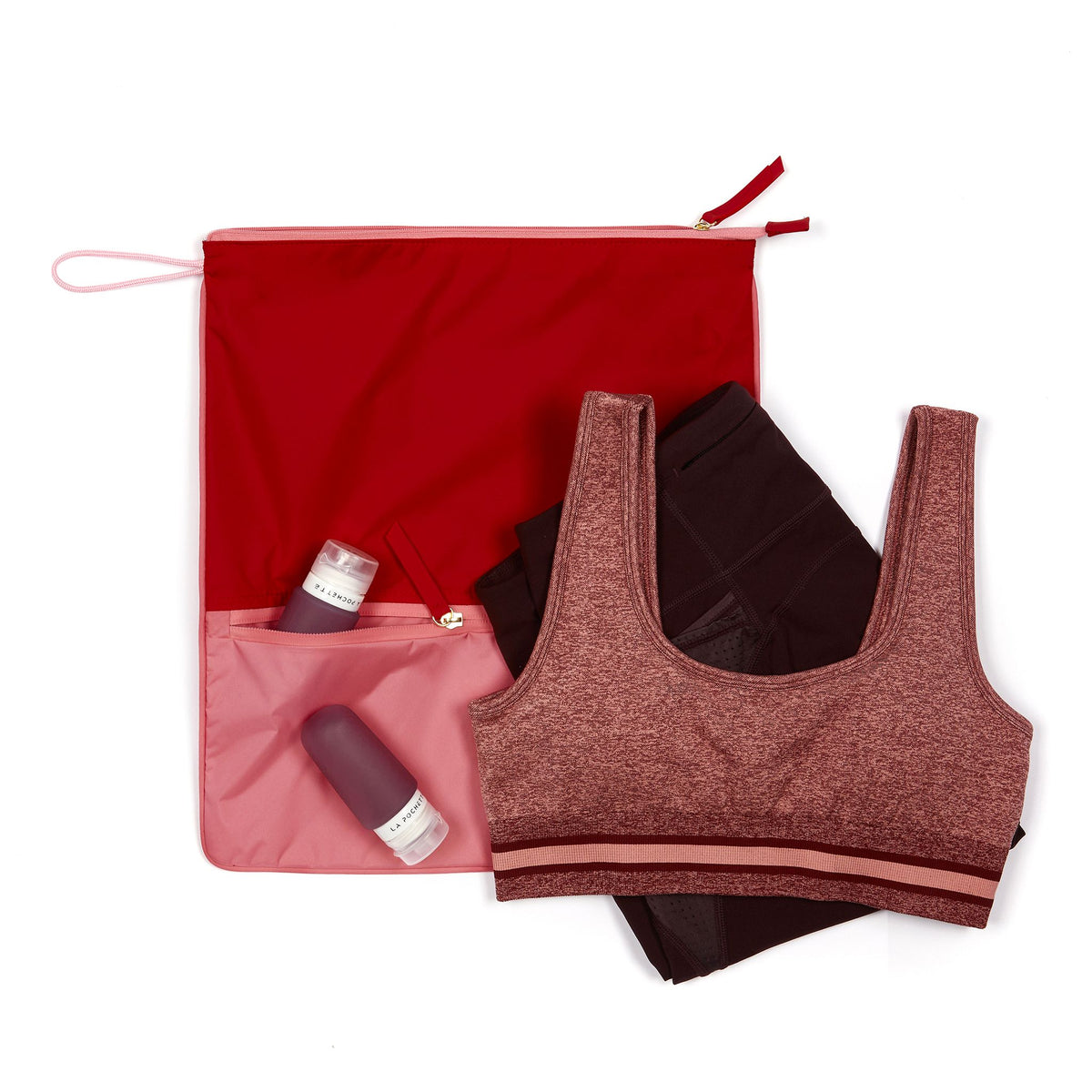 Chilli and peony Sweat Bag shown flat, with folded gym clothes and La Pochette silicone travel bottles