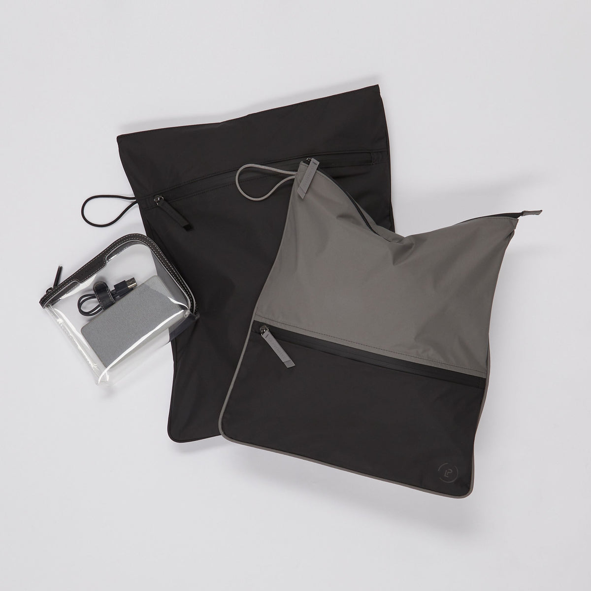 Pewter Ink Sweat Bag laid flat, topped with a small La Pochette Anywhere Everything Bag and La Pochette kit bag