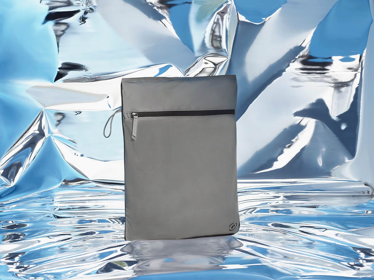 Kit Bag in dark grey and black on a blue mirrored abstract backdrop
