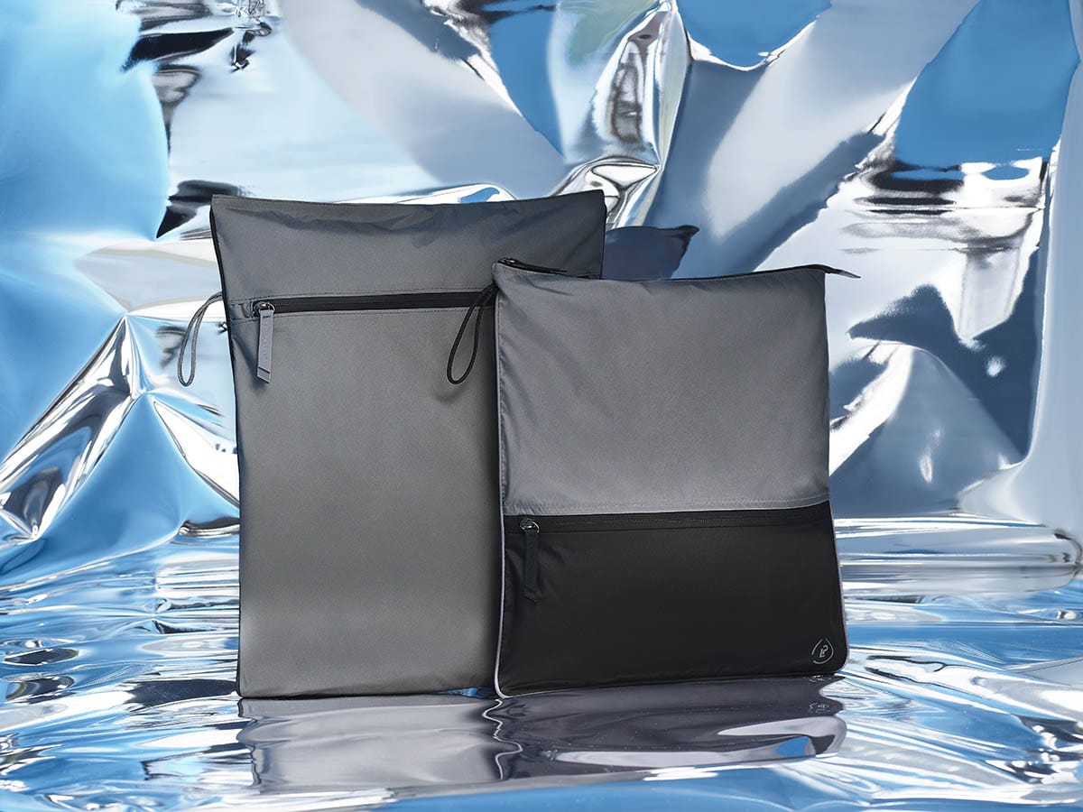 Kit and Sweat Bag Bundle in grey and black on a blue mirrored abstract background