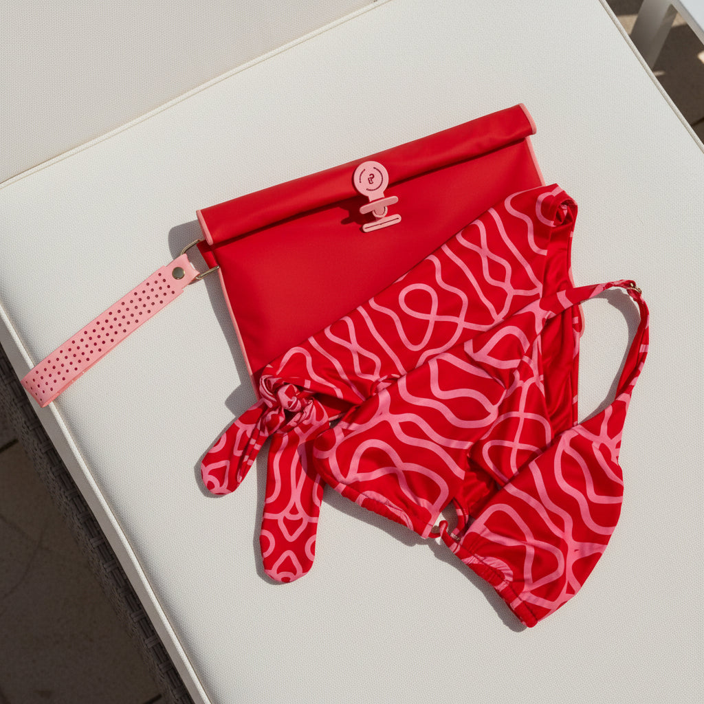 Large Wet Bag in vibrant red and pink styled flat with a red bikini a sun lounger